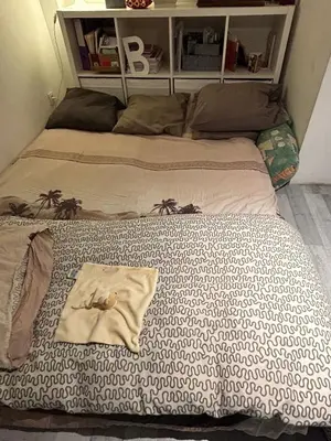 a bed with a shirt on top of it at Belle chambre de 1,30 cm de hauteur à Bruxelles midi in Brussels