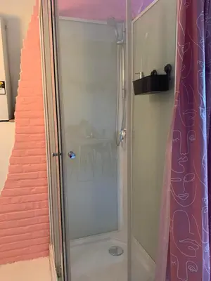a shower with a glass door next to a staircase at Cozy loft in private house at the center of Ghent in Ghent
