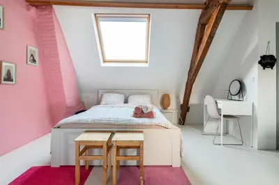 a bedroom with a bed with a pink wall at Cozy loft in private house at the center of Ghent in Ghent