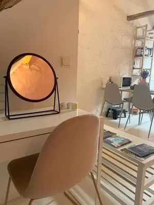 a mirror sitting on top of a table with a chair at Cozy loft in private house at the center of Ghent in Ghent