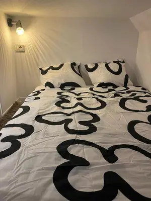 a bed with a black and white comforter on it at Cosy studio in prime location in Ghent