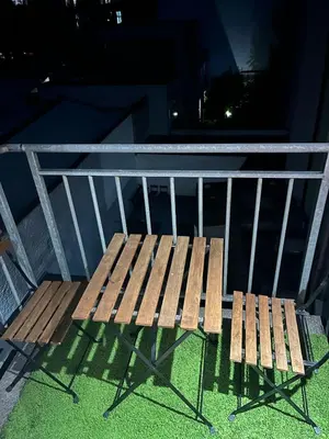 a wooden bench sitting on a balcony at night at Cosy studio in prime location in Ghent