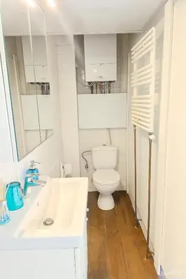 a white bathroom with a toilet and a sink at Cosy studio in prime location in Ghent