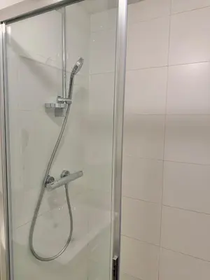 a shower with a hose in a glass door at Centre ville de Bruxelles in Brussels
