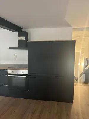 a kitchen with black cabinets and a stove at Мини студия in Antwerp