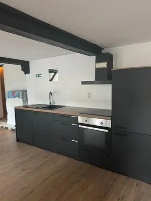 a kitchen with black cabinets and a sink at Мини студия in Antwerp