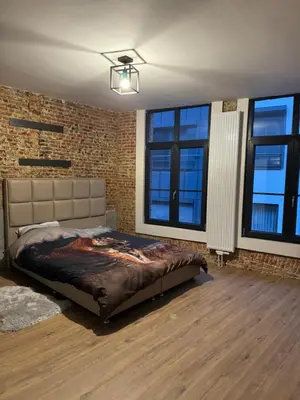 a bedroom with a bed and a brick wall at Мини студия in Antwerp