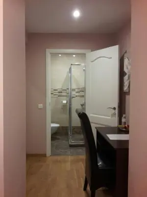 a bathroom with a sink and a desk and a shower at EU Guesthouse in Brussels