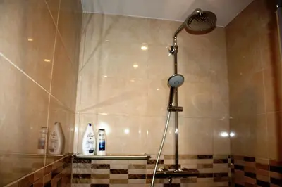 a shower with a shower head in a bathroom at EU Guesthouse in Brussels