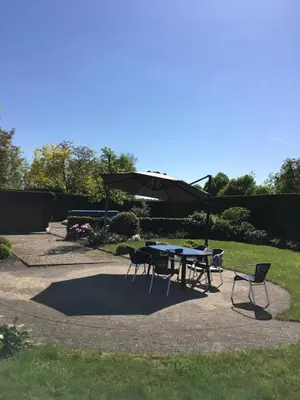 a table and chairs with an umbrella on a patio at Hotel Cleo in Kasterlee
