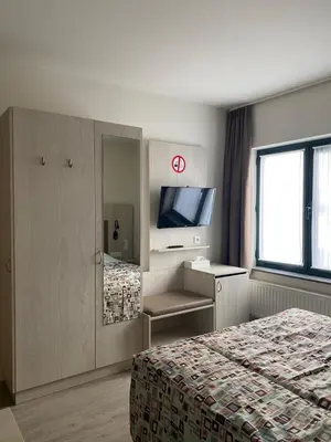 a hotel room with a bed and a television at Hotel Cleo in Kasterlee