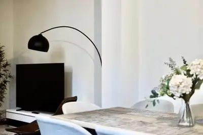 a dining room with a table with a lamp and a television at Spacious terrace apartment in the heart of Brussels in Brussels