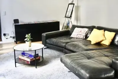 a living room with a leather couch and a table at Spacious terrace apartment in the heart of Brussels in Brussels