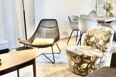 a living room with chairs and a table and a couch at Spacious terrace apartment in the heart of Brussels in Brussels