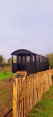 a black house sitting on top of a wooden fence at BelleLiv in Nijlen