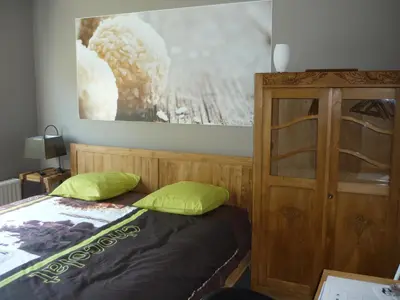 a bedroom with a bed and a wooden cabinet at B&B Wiezebed in Wieze