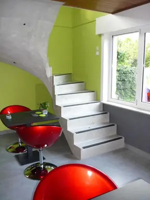 a staircase in a room with red chairs and a table at B&B Wiezebed in Wieze