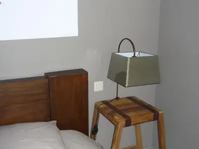 a lamp on a wooden table next to a bed at B&B Wiezebed in Wieze