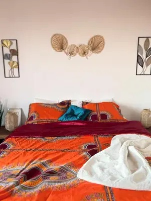a bed with a colorful comforter on it at Purple Sofa in Antwerp