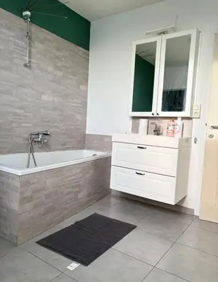 a bathroom with a white tub and a sink at Purple Sofa in Antwerp