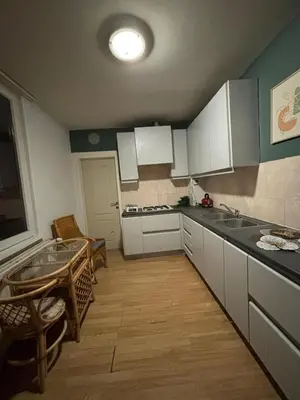 a kitchen with white cabinets and a table in it at Purple Sofa in Antwerp