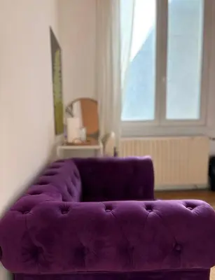 a purple couch in a living room with a window at Purple Sofa in Antwerp