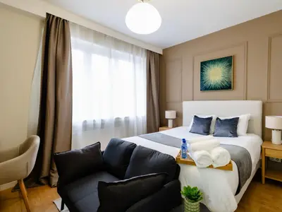 a bedroom with a bed and a couch at Charmant Studio - Centre-ville - 2min de Métro - 401 in Brussels