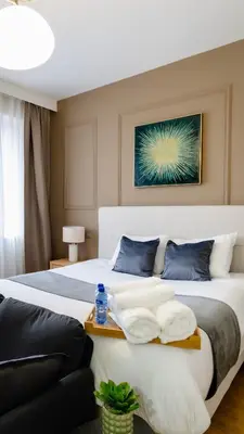 a bedroom with a large white bed with blue pillows at Charmant Studio - Centre-ville - 2min de Métro - 401 in Brussels