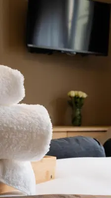 a white teddy bear sitting on top of a bed at Charmant Studio - Centre-ville - 2min de Métro - 401 in Brussels