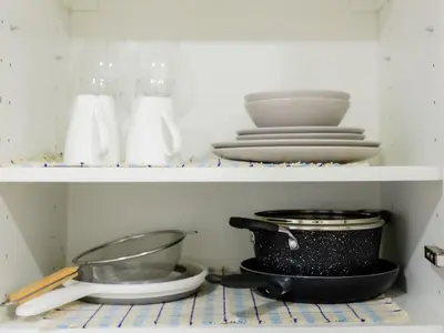 a shelf with plates and bowls and utensils at Cozy Studio - Downtown - 2 min from Metro - 201 in Brussels