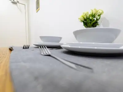 a table with plates and forks and a plant on it at Cozy Studio - Downtown - 2 min from Metro - 201 in Brussels