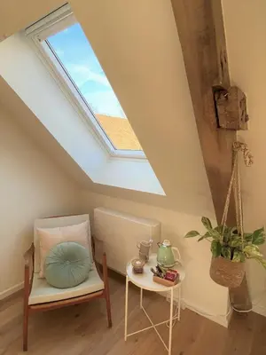 a skylight in a room with a chair and a table at The BEE Garden in Lede