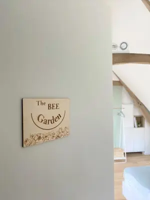a sign that reads the bee garage hanging on a wall at The BEE Garden in Lede