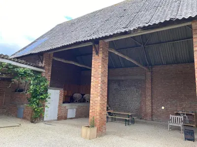 a brick pavilion with a table and a bench at The BEE Garden in Lede