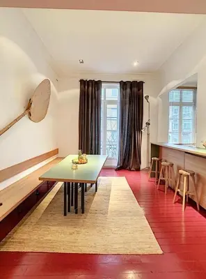 a living room with a table and a kitchen with windows at Loft a stone's throw from Place Brugmann in Brussels