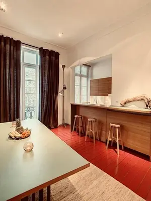 a kitchen with a table and stools in a room at Loft a stone's throw from Place Brugmann in Brussels