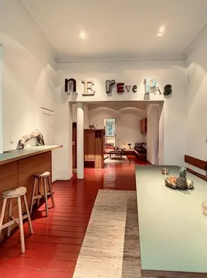 a kitchen and living room with a table and stools at Loft a stone's throw from Place Brugmann in Brussels