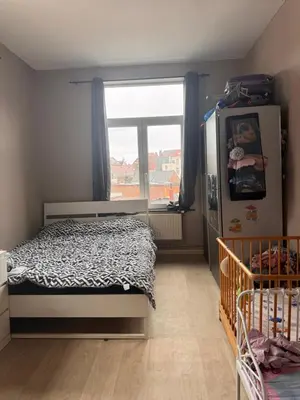 a small bedroom with a bed and a window at Appartement in Brussels