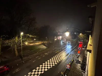 a city street at night with street lights at Appartement in Brussels