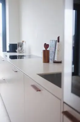 a white kitchen with a white counter top with a drawer at Design appartement met zonnig terras bij Gravensteen in Ghent