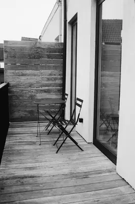 a table and chairs sitting on a porch at Design appartement met zonnig terras bij Gravensteen in Ghent