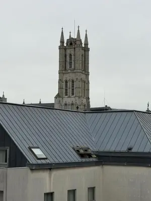 a building with a clock tower in the background at Kaffee Changé in Ghent