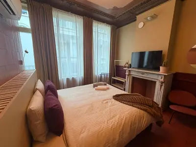 a bedroom with a bed with a fireplace and a television at Kaffee Changé in Ghent