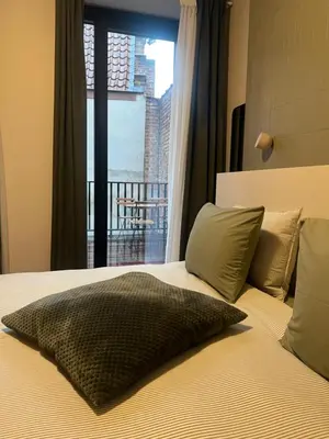 a bedroom with a bed with a view of a balcony at Kaffee Changé in Ghent
