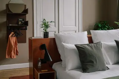 a bedroom with a white couch and a mirror at A Place Antwerp - Boutique Suites & Flats - Schuttershofstraat 1 in Antwerp