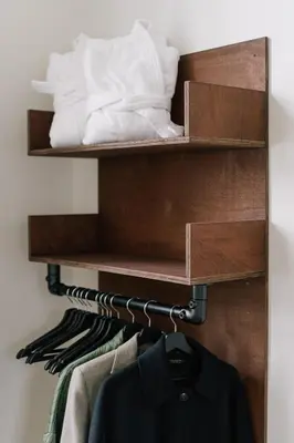 a shelf in a closet with clothes at A Place Antwerp - Boutique Suites & Flats - Schuttershofstraat 1 in Antwerp