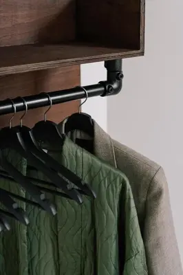 a green jacket is hanging on a rack at A Place Antwerp - Boutique Suites & Flats - Schuttershofstraat 1 in Antwerp