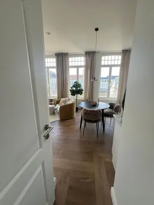 a view of a living room with a table and chairs at Maison Violette Antwerp in Antwerp