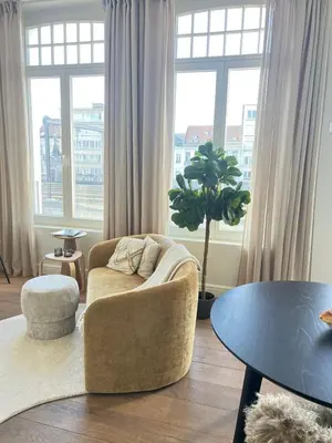 a living room with a couch and a table at Maison Violette Antwerp in Antwerp