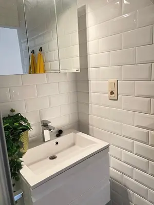 a white bathroom with a sink and a mirror at Maison Violette Antwerp in Antwerp